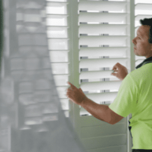 man fixing plantation shutter